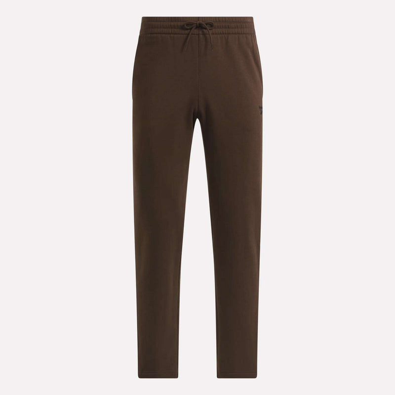 Men’s Open Hem Pants by Reebok featuring an elastic waistband, drawstring tie, and relaxed fit. These brown pants come with side pockets, a subtle Reebok logo on the left hip, and are displayed against a plain light background.