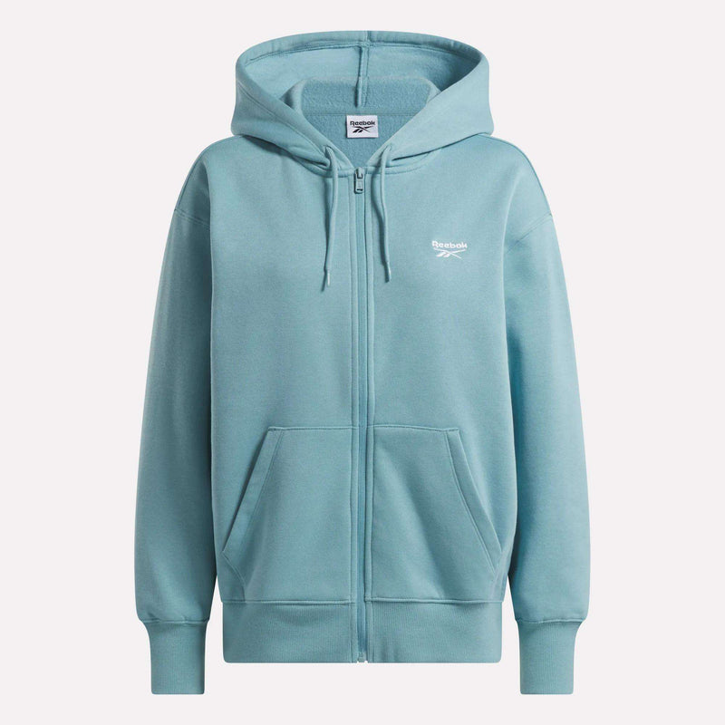 Women’s Oversized Full-Zip Hoodie by Reebok in light blue, featuring a modern cut, front pockets, and a small white Reebok logo on the left chest, shown on a plain background.