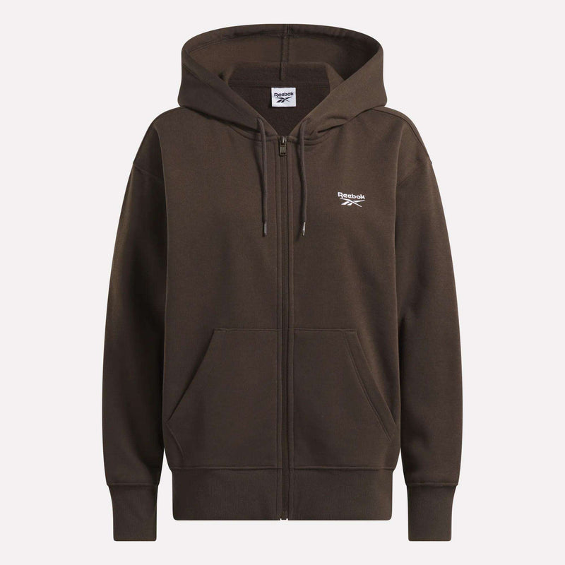 The Reebok Women’s Oversized Full-Zip Hoodie in brown features a modern cut, hood, front pockets, drawstrings, and a small white Reebok logo on the left chest.