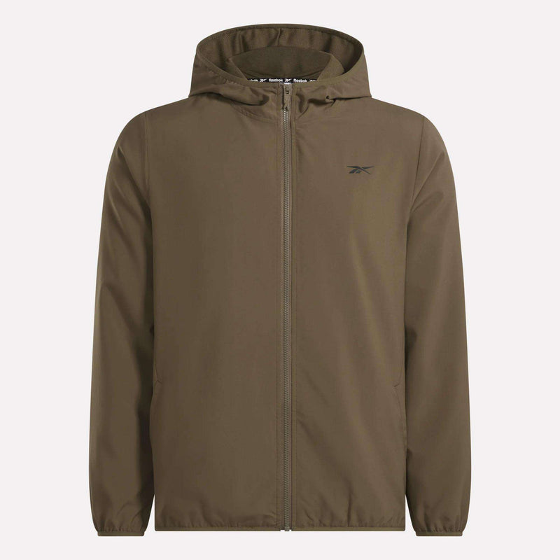 The Men’s Woven Jacket by Reebok is a brown zip-up hooded jacket featuring a subtle black Reebok logo on the left chest, two side pockets, and a clean design with no visible buttons or drawstrings. Shown against a plain white background, this lightweight piece is a versatile addition to your training gear collection.