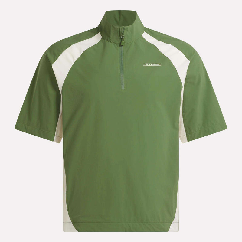 The Reebok x Manors Men’s Tour Shirt is a green, short-sleeved golf pullover featuring a half-zip front, high collar, and white panels on the shoulders and sides. This men’s shirt from Reebok’s collaboration with Manors displays a small logo on the left chest.
