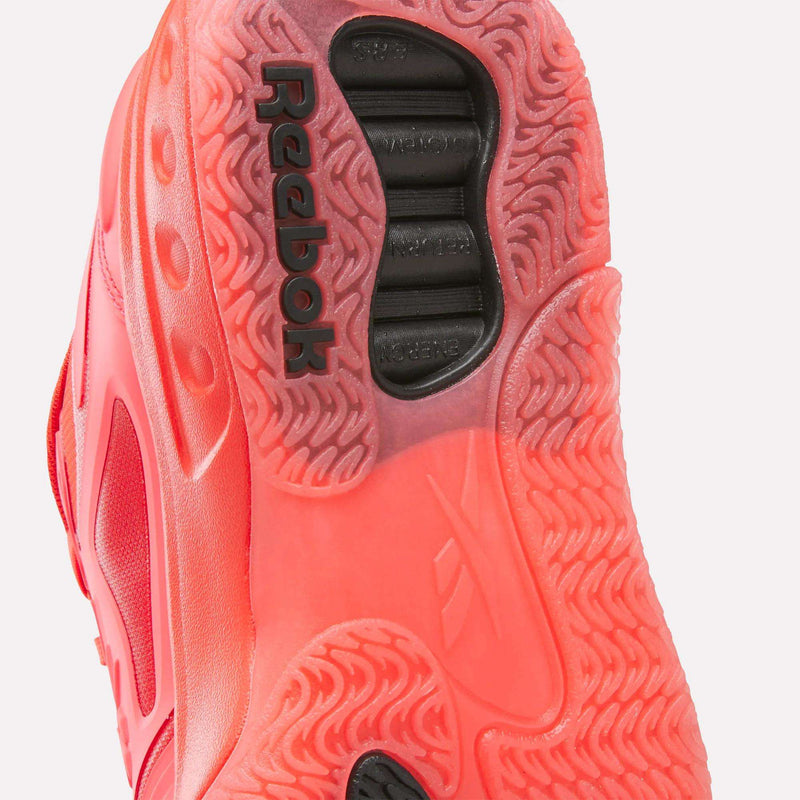Close-up of a bright red Reebok Engine A basketball shoe sole featuring a textured tread pattern and a recessed black heel insert with ERS technology.