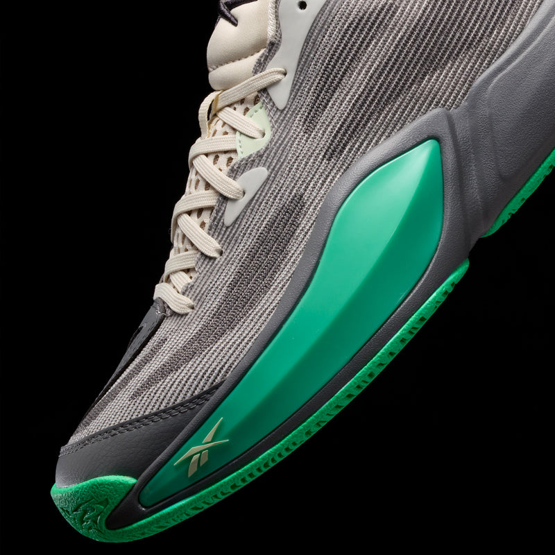 Close-up of a grey Reebok Engine A 26 basketball shoe with a bright green midsole and engineered mesh upper.