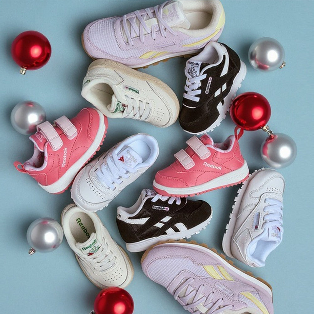 Collection of children's sneakers with Christmas ornaments on a light blue background