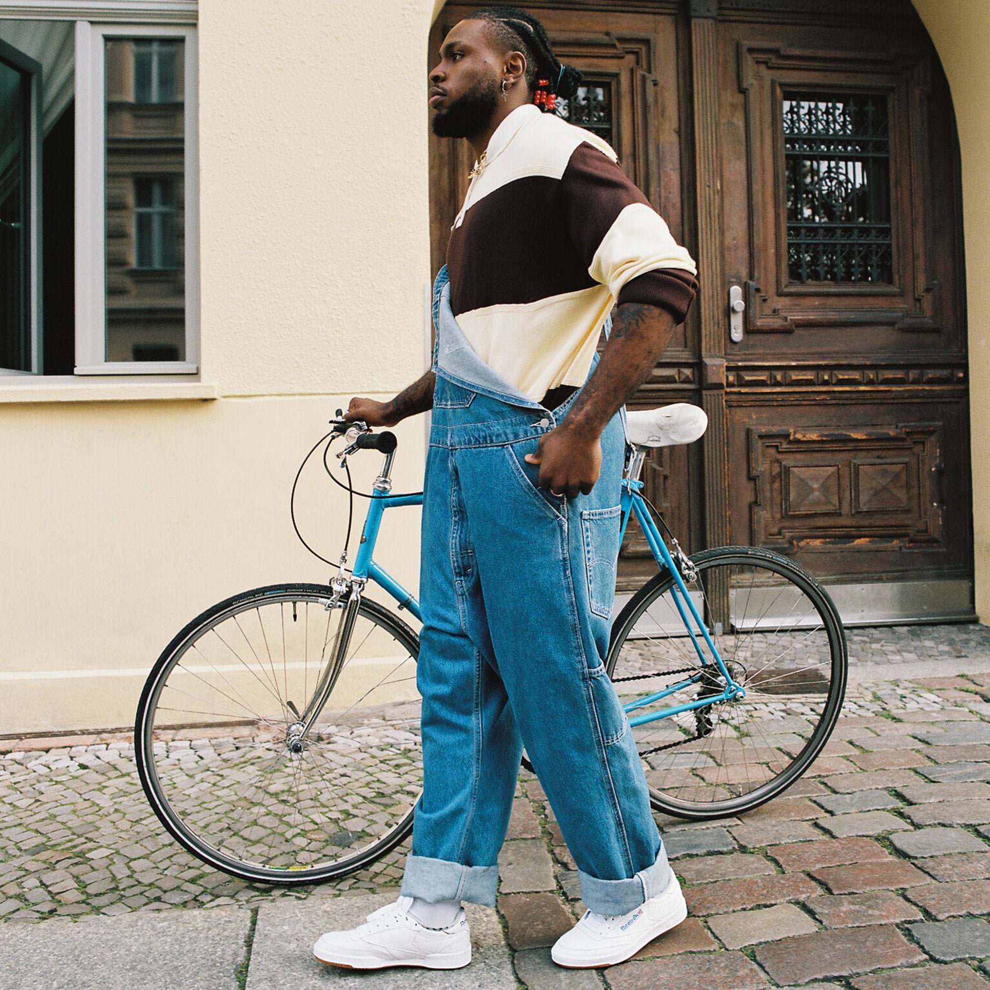 A man with a bike on a brick city street.