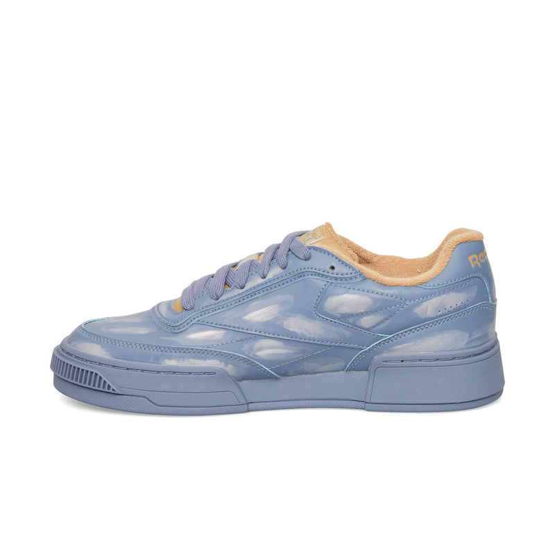 Reebok Club C LTD sneaker in periwinkle blue with a glossy, cloud-like pattern, matching laces, and a tan interior lining.