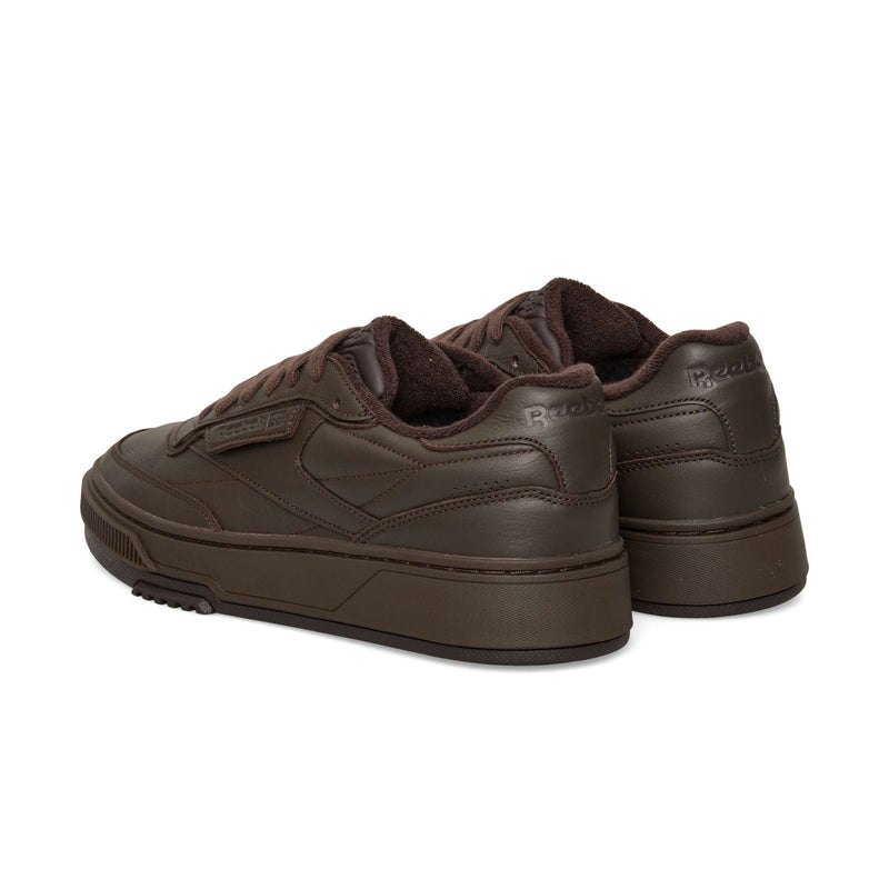 A pair of dark brown Reebok Club C LTD low-top sneakers shown from the rear and side angle as a classic lifestyle tennis shoe.