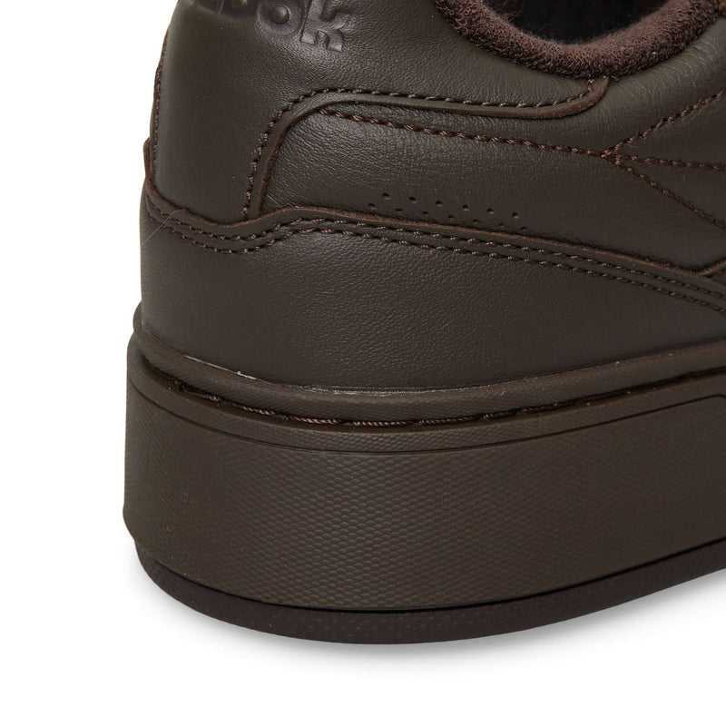 Close-up of the heel area of a dark brown Reebok Club C LTD tennis shoe, showing the textured midsole and stitched upper.