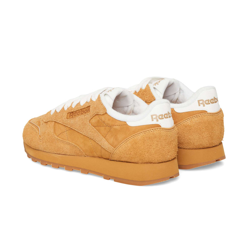 Tan suede Reebok Classic Leather Premium sneakers featuring white collars and gum rubber soles.