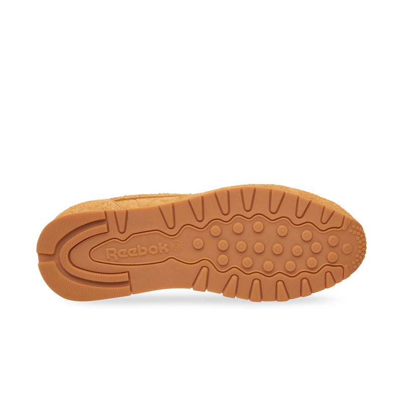 The gum rubber outsole of Reebok Classic Leather Premium sneakers, featuring a textured tread pattern and a debossed logo in the center.