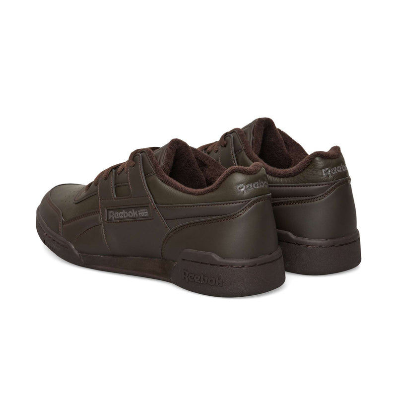 Two dark brown Reebok Workout Plus OG sneakers shown from a back three-quarter view, featuring a classic silhouette.