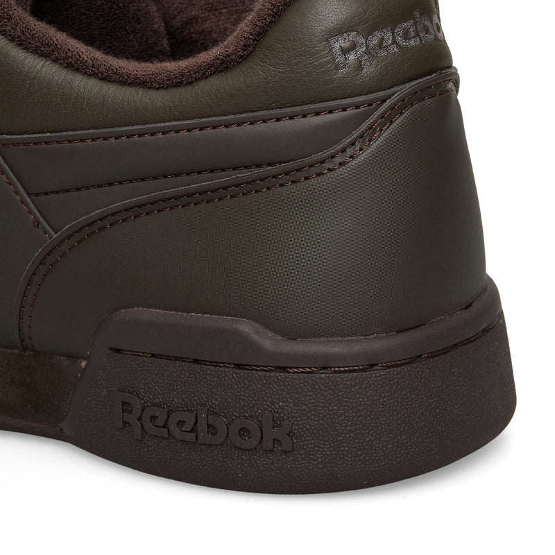Close-up of the heel area of dark brown Reebok Workout Plus OG sneakers, showing the branding embossed on the collar and the textured rubber midsole.