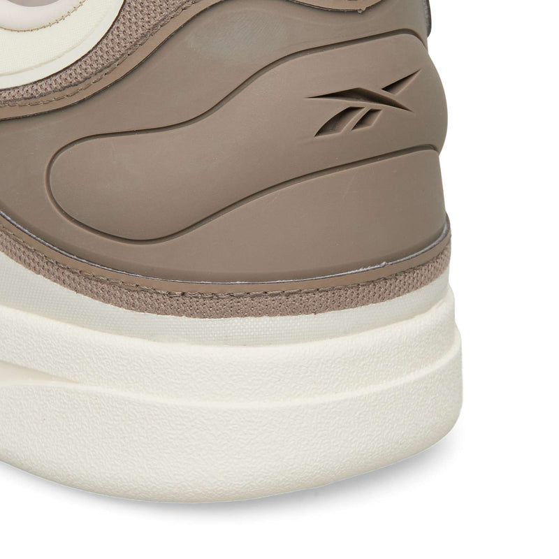 Close-up of the heel area of tan and white Reebok Hammer Pro LTD sneakers, featuring an embossed logo on the side and a durable rubber sole.