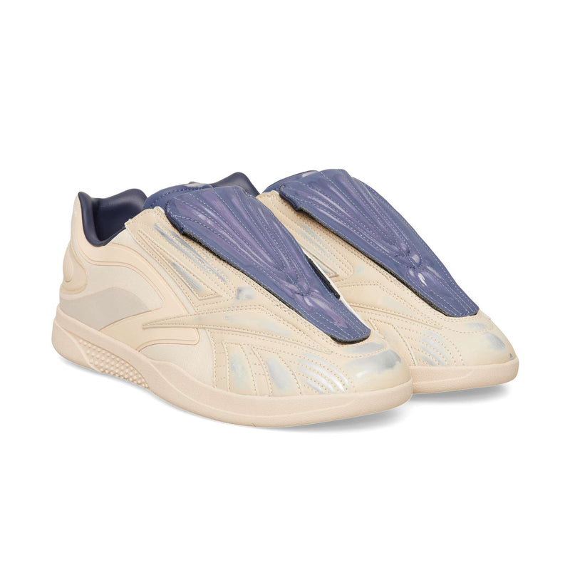 Cream-colored Reebok Hammer Pro LTD low-top sneakers with a durable rubber sole and a prominent blue ridged tongue overlay.