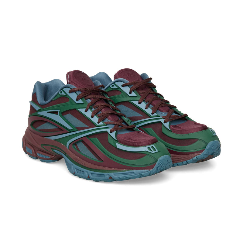 Reebok Premier Road Modern low-top running sneakers in maroon, teal, and blue, featuring a futuristic layered panel design and thick rubber soles.