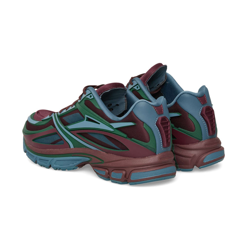 A rear three-quarter view of a Reebok Premier Road Modern in panels of burgundy, teal, and dark green, showcasing the futuristic sneaker silhouette.