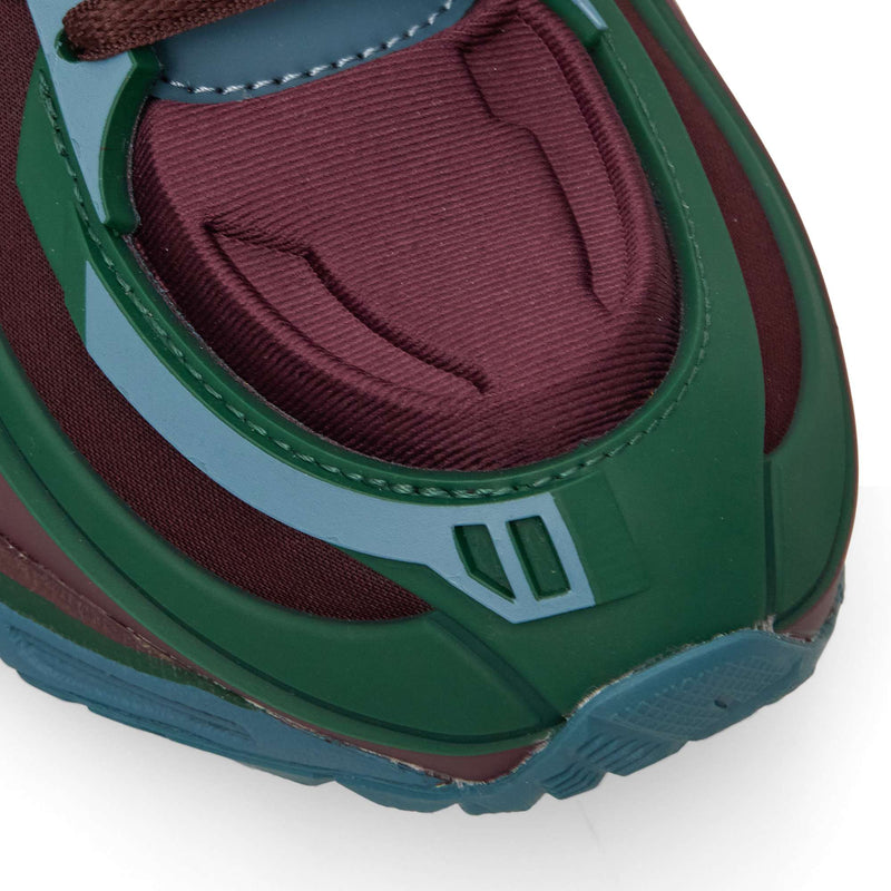 Close-up of the Reebok Premier Road Modern toe box, featuring layered panels in maroon, dark green, and light blue.
