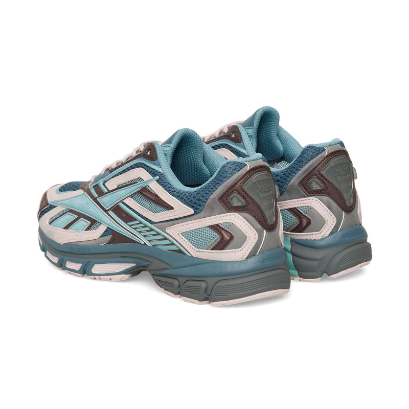 Two Reebok Premier Road Ultra athletic sneakers in shades of blue, burgundy, and beige, viewed from the rear three-quarter angle to highlight their dual-density midsole.