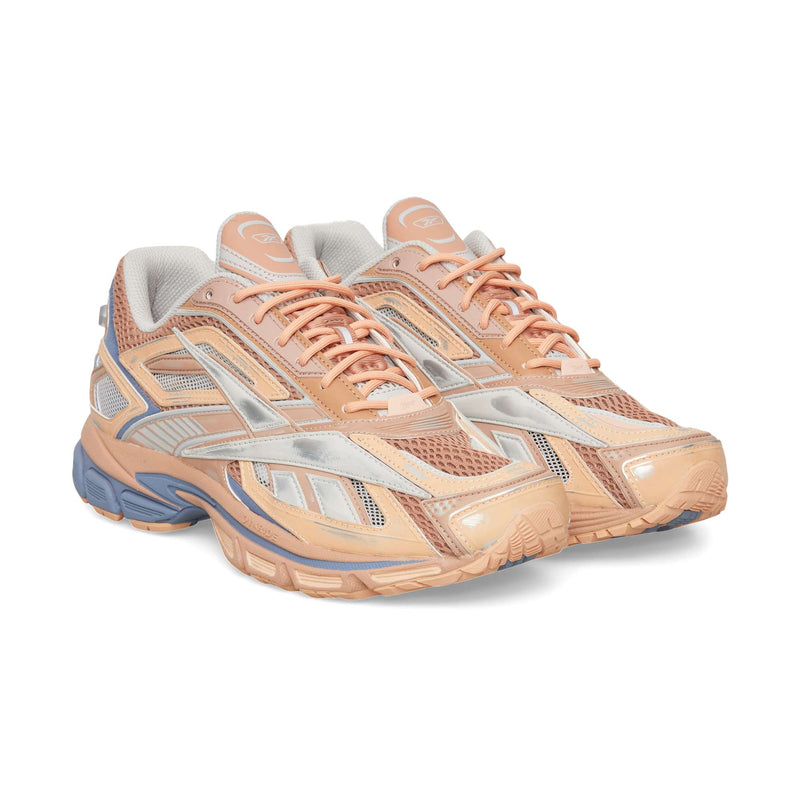 A pair of peach-colored Reebok Premier Road Ultra athletic sneakers with mesh panels and grey detailing.