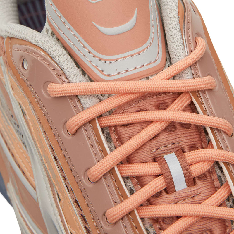 Close-up of a peach-toned Reebok Premier Road Ultra with matching laces and a reflective tab on the tongue, highlighting its archival running silhouette.