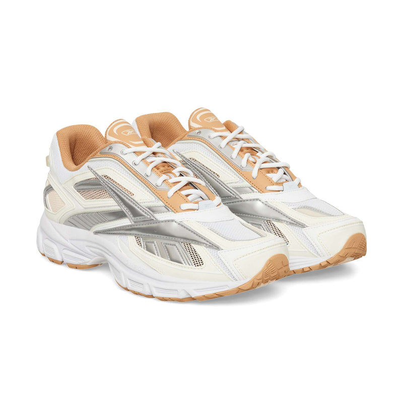 White, silver, and tan Reebok Premier Road Ultra running sneakers featuring mesh panels, white laces, and a dual-density midsole with gum-colored outsoles.