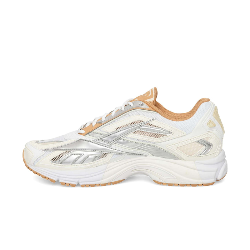 White Reebok Premier Road Ultra running sneaker featuring silver metallic accents, white mesh panels, and a tan rubber outsole.