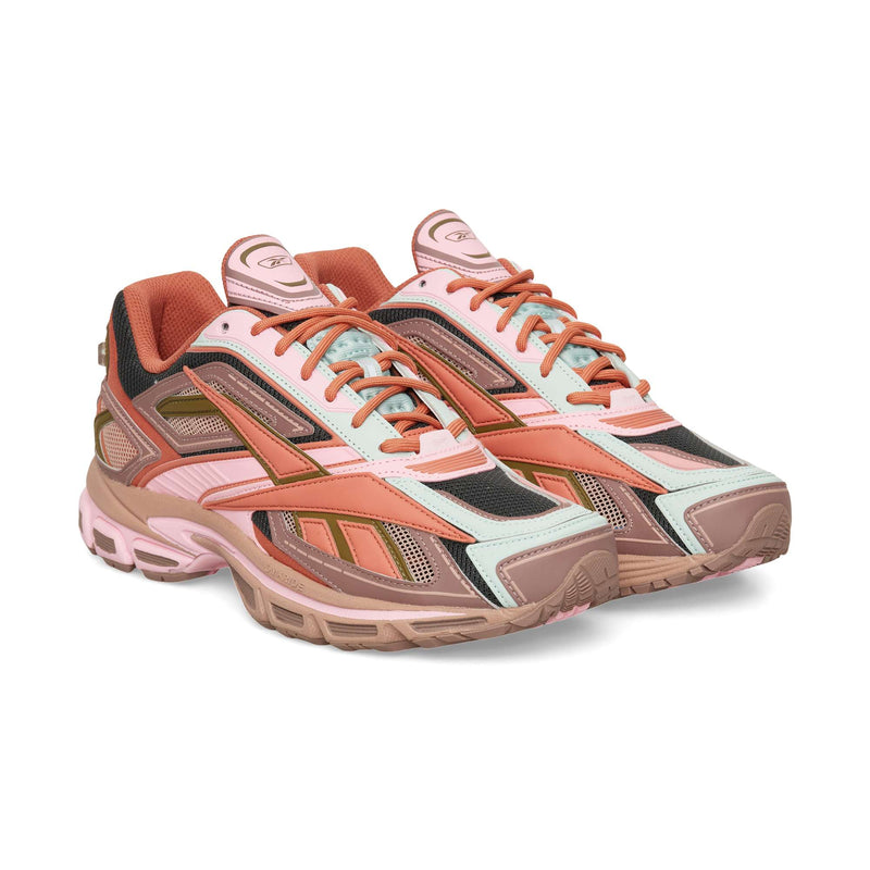 Reebok Premier Road Ultra low-top athletic sneaker in shades of pink, tan, mint green, and black with mesh and synthetic overlays featuring a dual-density midsole.