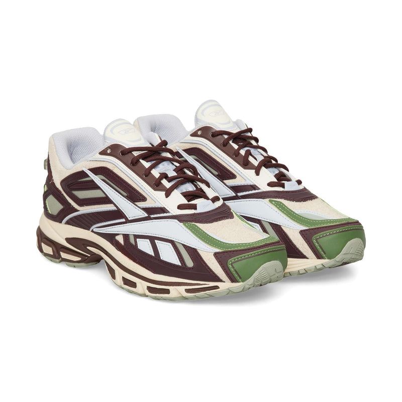 A pair of Reebok Premier Road Ultra running shoes featuring a chunky silhouette in shades of cream, brown, and olive green with dark brown laces.