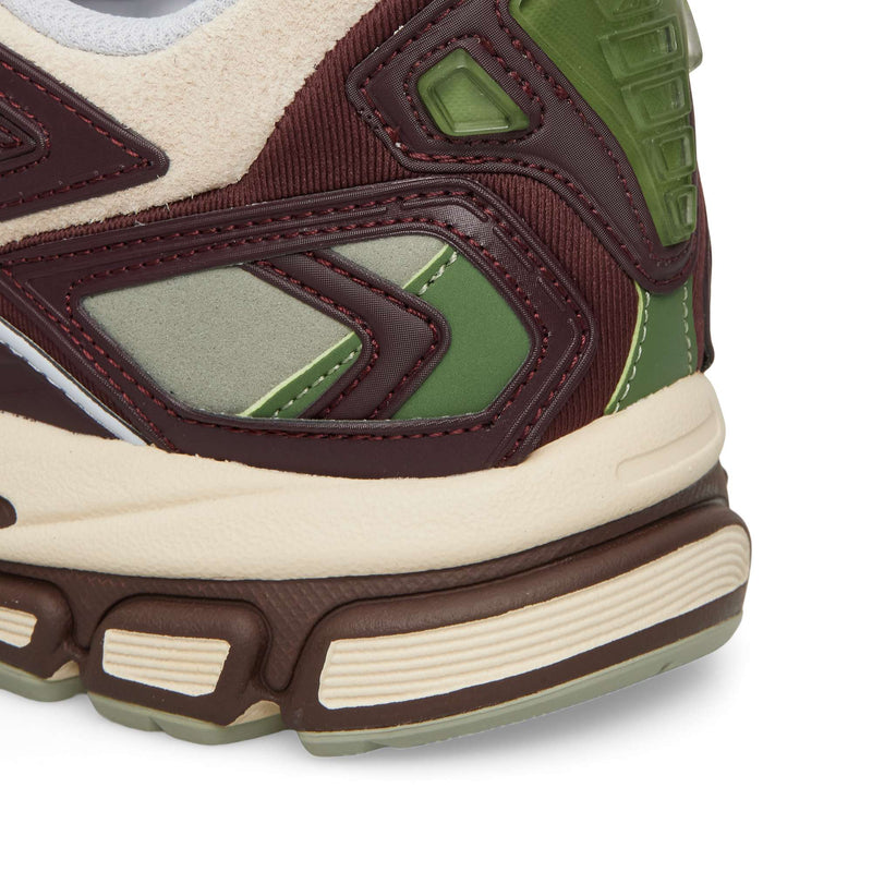 Close-up of the heel area of a Reebok Premier Road Ultra featuring burgundy, olive green, and cream panels with a stacked dual-density midsole.