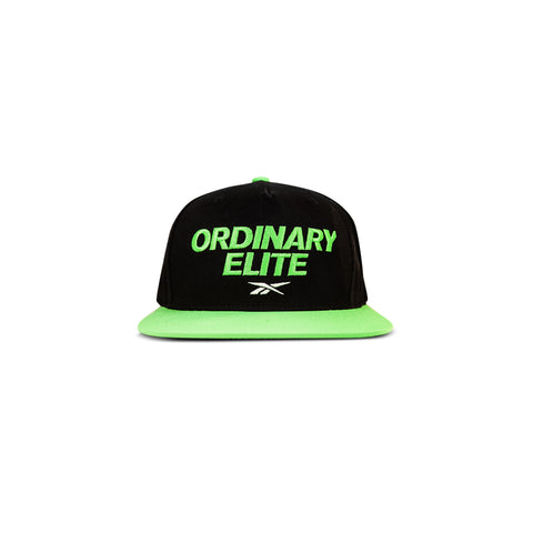The Reebok Ordinary Elite Cap features a black design with a bright green flat brim, bold green "ORDINARY ELITE" embroidery on the front, a small white logo beneath, and an adjustable snapback closure for comfort.