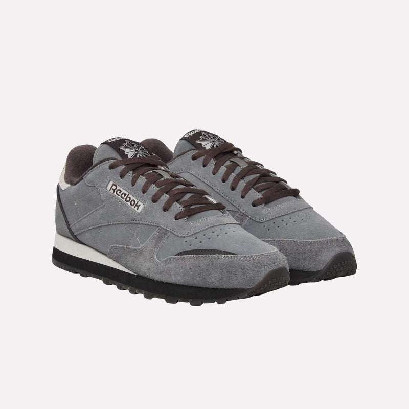 A pair of Reebok Classic Leather Premium LTD Shoes in gray, featuring black laces and soles with contrasting white midsoles. Displaying a timeless silhouette, these retro sneakers are arranged side by side against a plain white background.
