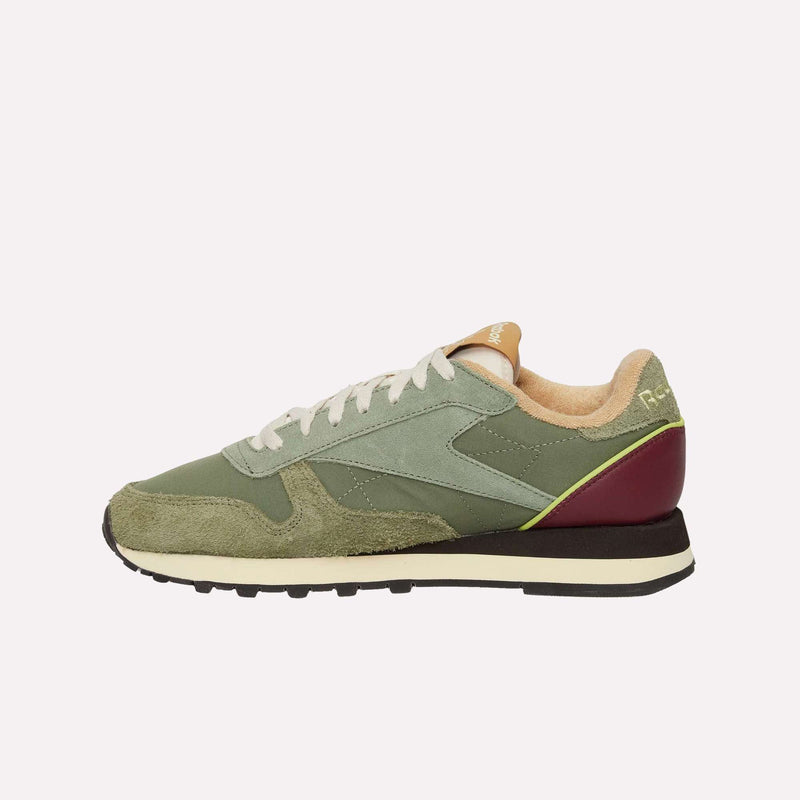 The Reebok Classic Leather Premium LTD Shoes display retro charm with their green and beige design, white laces, dark red heel accent, and black-and-white sole, all set in a timeless silhouette against a plain light background.