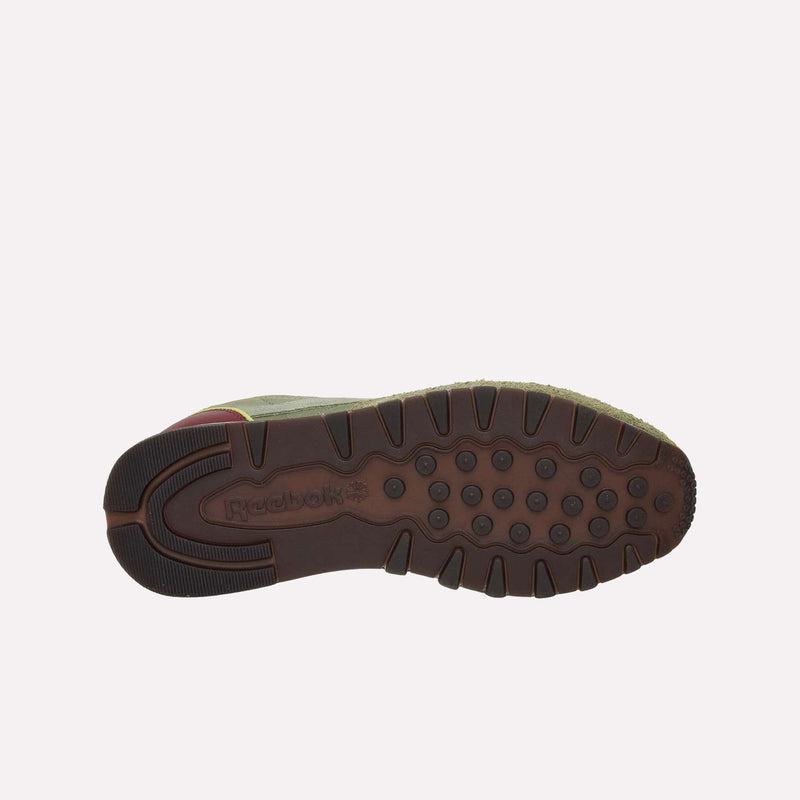 The bottom view of the Reebok Classic Leather Premium LTD Shoes features a brown, textured sole with round treads and the Reebok logo embossed near the heel, emphasizing its classic silhouette and vintage appeal.