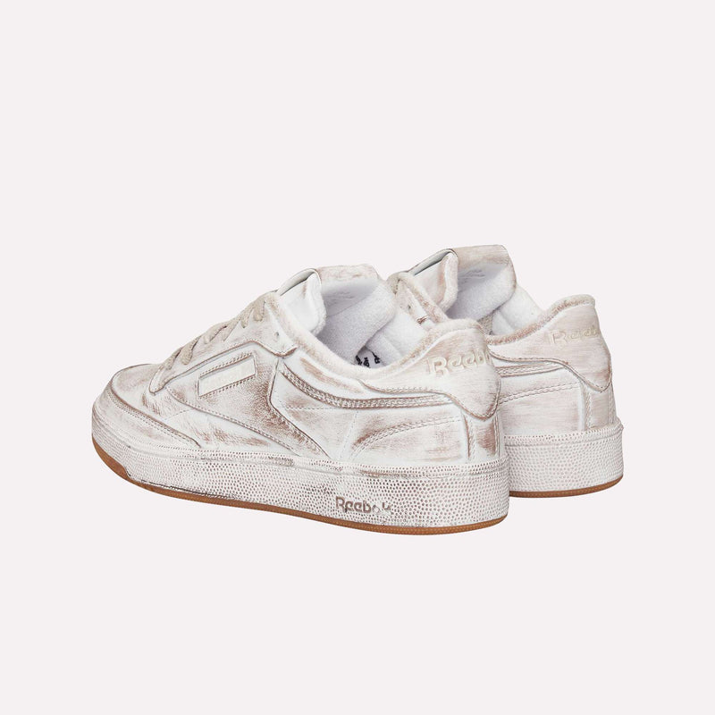 A pair of Reebok Club C 85 Vintage LTD Shoes in white with beige accents, seen from the back and side on a simple light background—an effortlessly cool update to a classic lifestyle tennis sneaker.