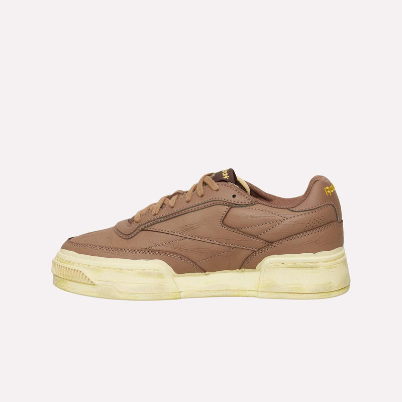 The Reebok Club C LTD Shoes, crafted in brown leather with a yellowed sole and yellow accents, are displayed in a side profile against a plain light background, delivering a timeless update to this lifestyle classic.