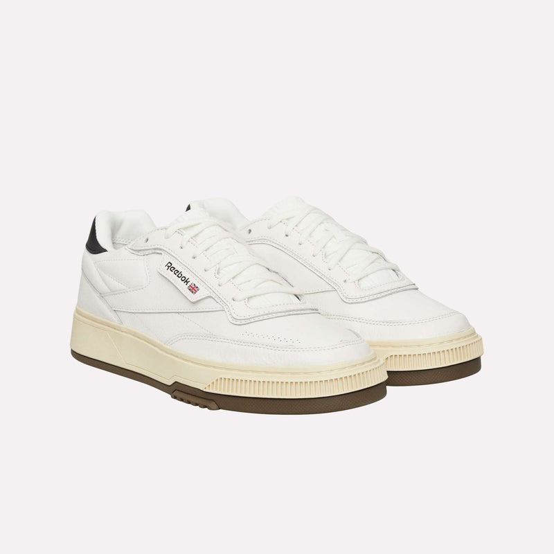 A pair of Reebok Club C LTD Shoes in white with off-white soles and black heel accents, showcased on a plain white background for a refined update to this lifestyle classic.