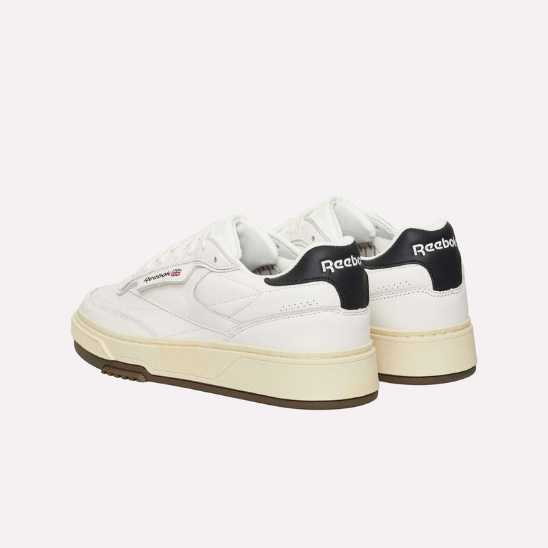 A pair of Reebok Club C LTD Shoes in white, featuring cream-colored soles and black accents on the heel, shown from the back and side against a plain background—offering a fresh interpretation of this lifestyle classic.