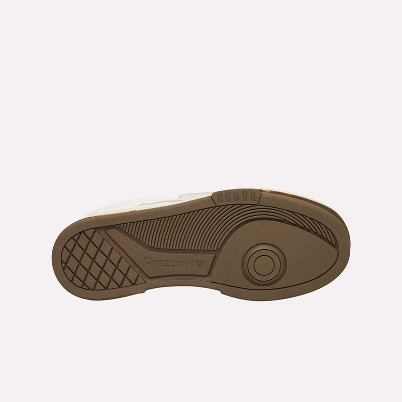 The image displays the sole of a Reebok Club C LTD shoe, featuring a brown tread pattern with geometric details and the Reebok logo embossed near the heel, highlighting the enduring style of this iconic lifestyle sneaker.