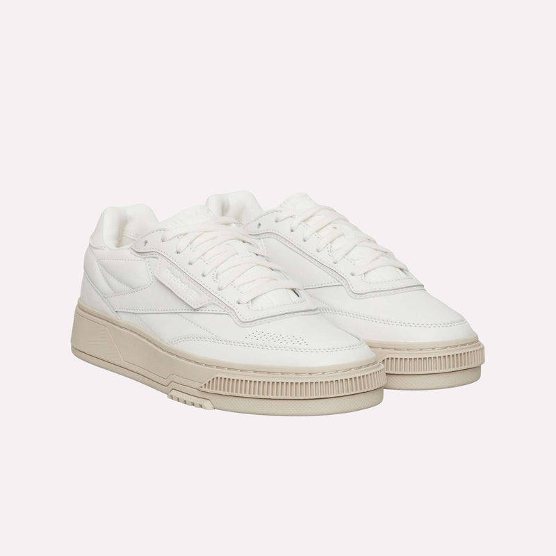 A pair of Reebok Club C LTD Shoes, featuring a white low-top design with off-white soles, laces, and stitching details that capture a classic lifestyle aesthetic reminiscent of the iconic Club C style, displayed on a plain white background.