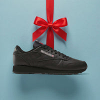 black reebok classic shoe with red ribbon 