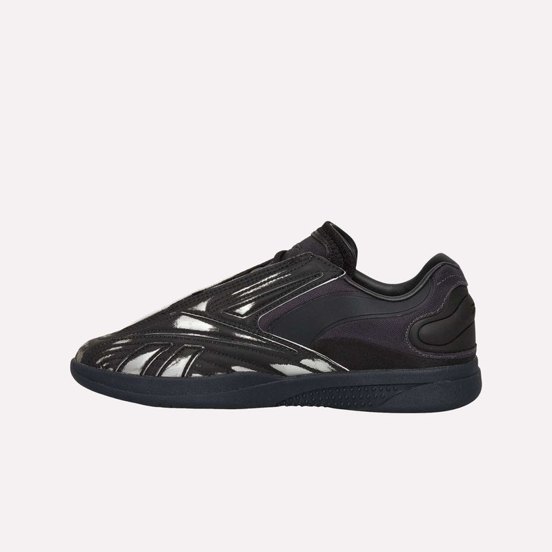 Showcased in a side view against a plain light background, the Reebok Hammer Pro LTD Shoes feature a black colorway with a sleek design, durable rubber sole, and shiny silver accents along the sides.