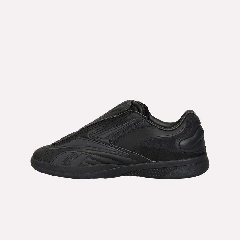 The Reebok Hammer Pro LTD Shoes are shown in a side profile view against a plain light background. This black faux leather sneaker features a sleek, minimalist design with no visible laces and is finished with a durable rubber sole for lasting comfort and style.