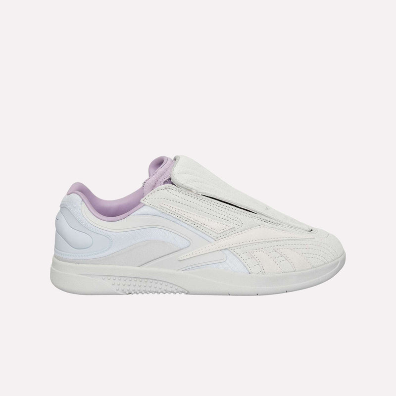 A side profile of the Reebok Hammer Pro LTD Shoes is displayed against a plain light background, highlighting their white and pastel purple colorway, suede upper, textured accents, sleek modern design, and low-top silhouette.