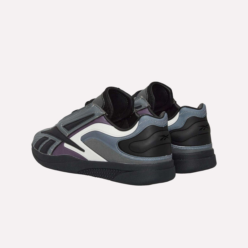 Two dark-colored Reebok Hammer Pro LTD Shoes with black, durable rubber soles; white accents; and purple and gray details feature a sleek faux leather upper. Shown from an angled rear view against a plain light background.