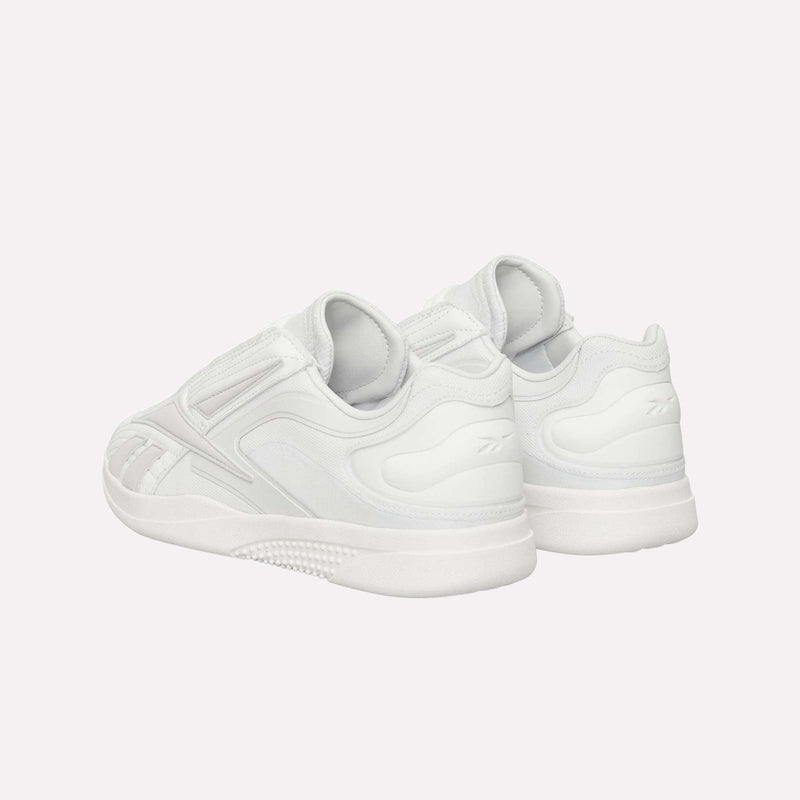 A pair of Reebok Hammer Pro LTD Shoes in white, featuring a subtle pattern and a thick, durable rubber sole, crafted from premium faux leather and arranged at an angle to highlight the heel and side details, set against a plain white background.