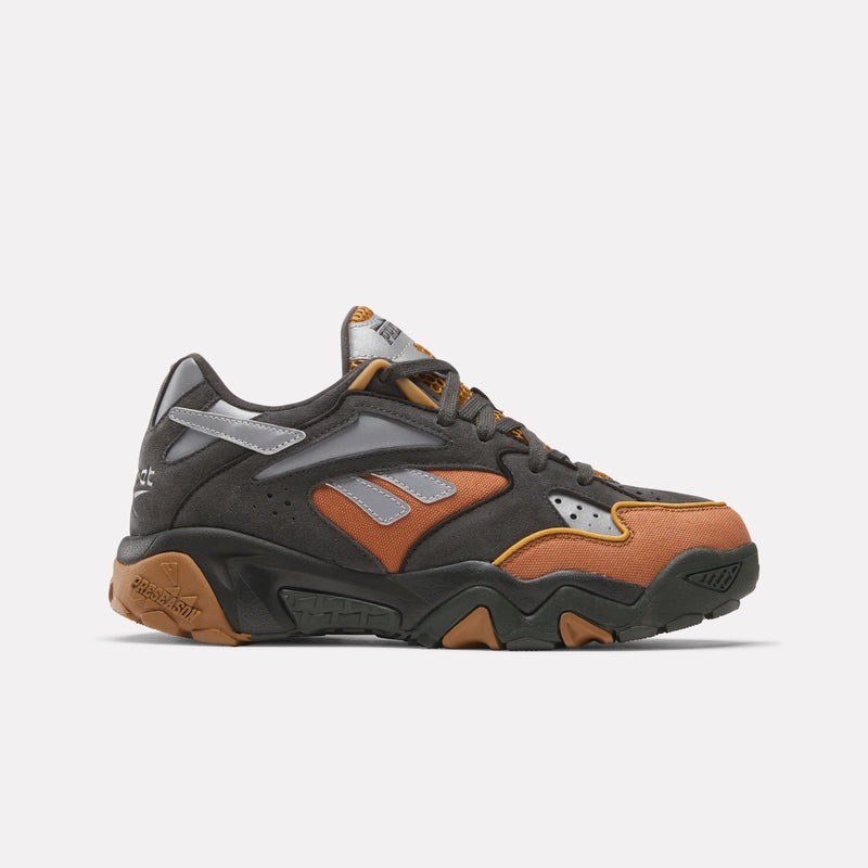 The Reebok x Market Preseason 94 Low Shoes from Reebok’s Preseason Collection showcase a dark gray upper with orange and brown accents, subtle gray logo details, and a bold, chunky orange and black textured sole—stylishly presented against a plain white background.