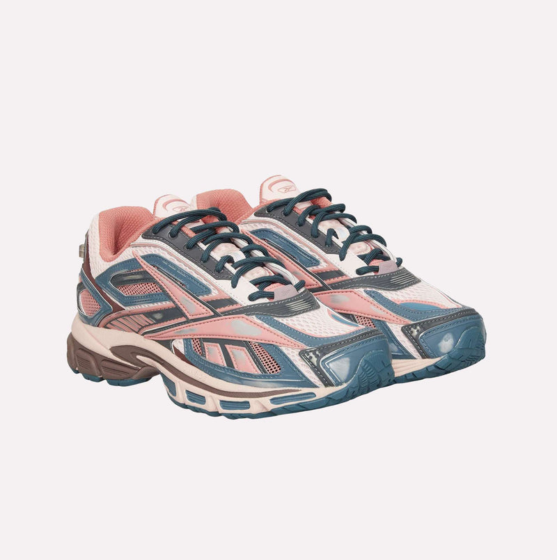 Introducing the Premier Road Ultra LTD Shoes by Reebok—athletic sneakers designed with pink, white, and blue accents. These shoes feature a combination of mesh and synthetic materials, chunky soles inspired by archival running sneaker designs, and a supportive dual-density midsole for enhanced comfort.