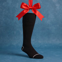 black sock hanging from red ribbon on light blue background
