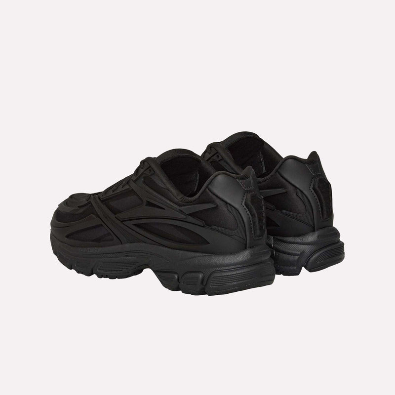 A pair of Reebok Premier Road Modern LTD Shoes in black are displayed on a light background, shown from the back and side. Taking cues from vintage running shoe designs, these sneakers boast thick soles and textured, layered detailing along the sides and heels for a futuristic look.
