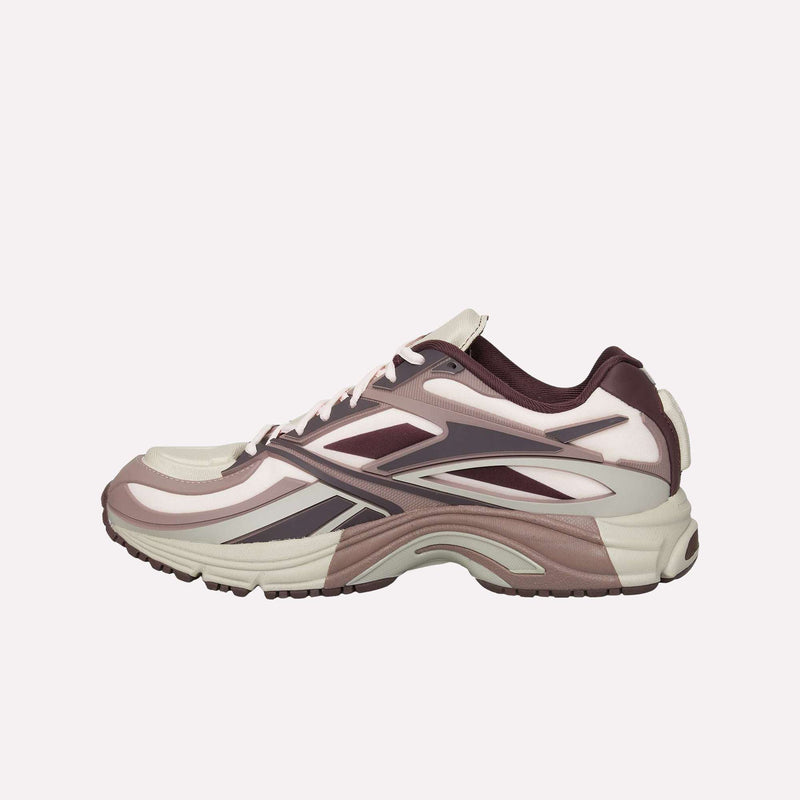 Introducing the Reebok Premier Road Modern LTD Shoes—a stylish sneaker inspired by archival running designs, featuring dynamic layered patterns in shades of pink, burgundy, and cream. Showcased in side profile against a plain light background, this model boasts a chunky dual-density midsole for enhanced comfort.